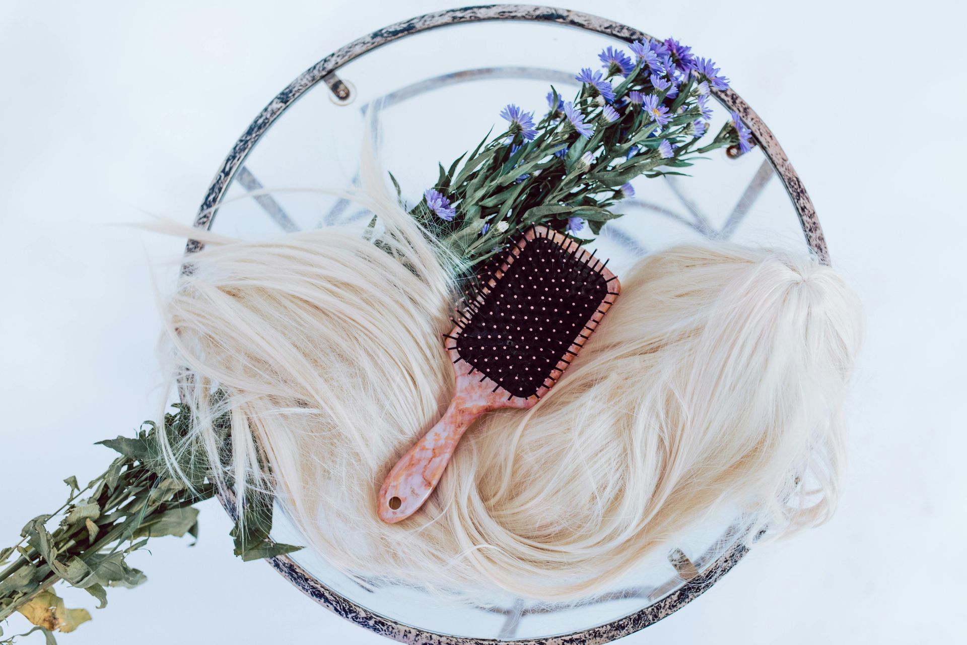 A brush is sitting on top of a bunch of blonde hair.