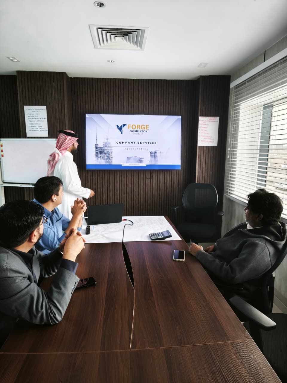 Person in green glove uses a drill on a wood board.