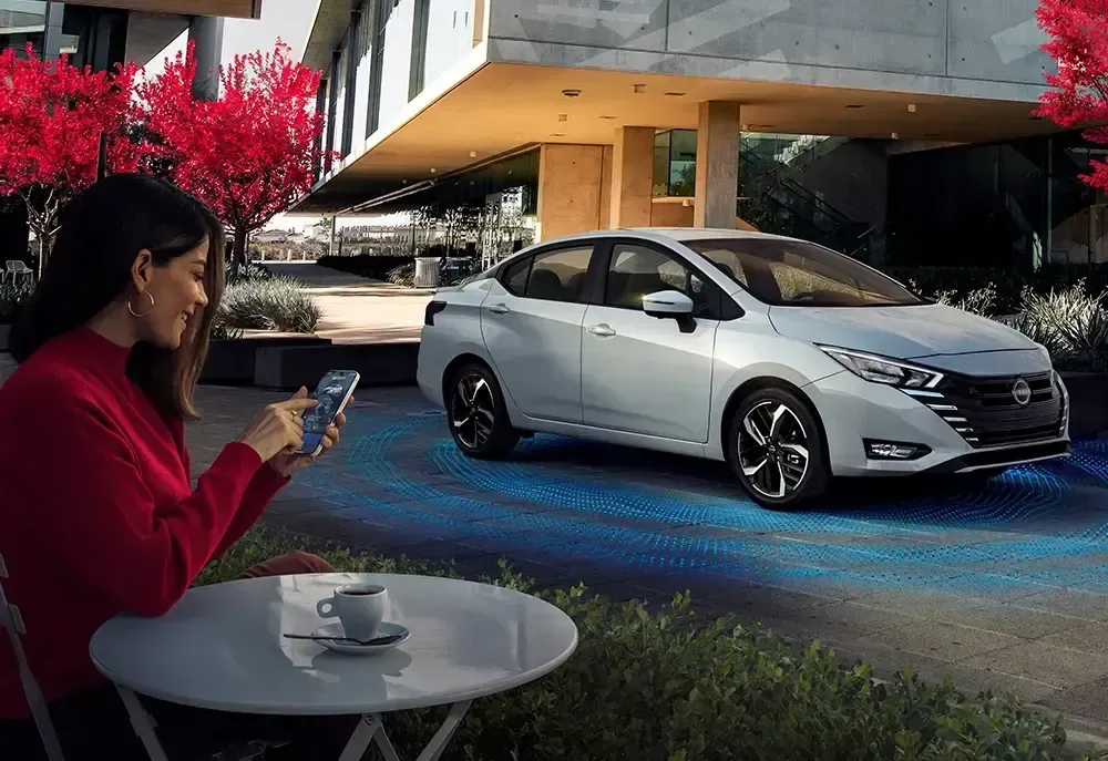 Um Nissan Kicks vermelho está estacionado na beira de uma rua da cidade.