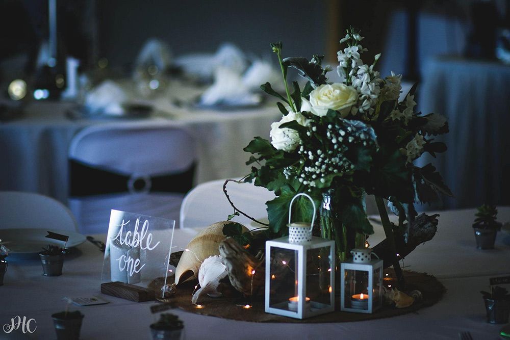 A Table With a Vase of Flowers and Lanterns on It — Central Coast Events in Berkeley Vale, NSW