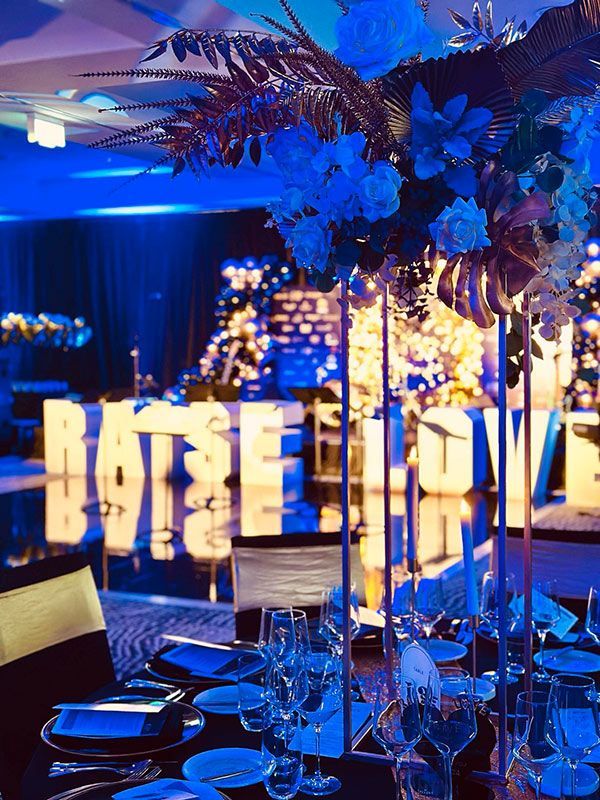 A Table With Plates, Glasses, and Flowers on It With a Sign — Central Coast Events in Berkeley Vale, NSW