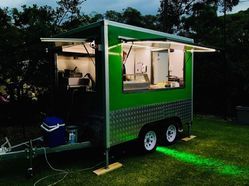 A Green Food Truck is Parked in a Grassy Field at Night ― Central Coast Events in Berkeley Vale, NSW