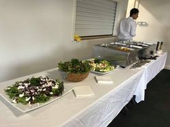 A Buffet Table With Plates of Food and a Man Standing Behind It ― Central Coast Events in Berkeley Vale, NSW