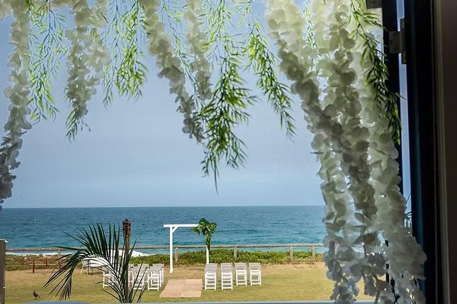 A View of the Ocean Through a Window Decorated With White Flowers ― Central Coast Events in Berkeley Vale, NSW