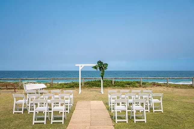 A Row of White Folding Chairs Sitting Next to the Ocean ― Central Coast Events in Berkeley Vale, NSW