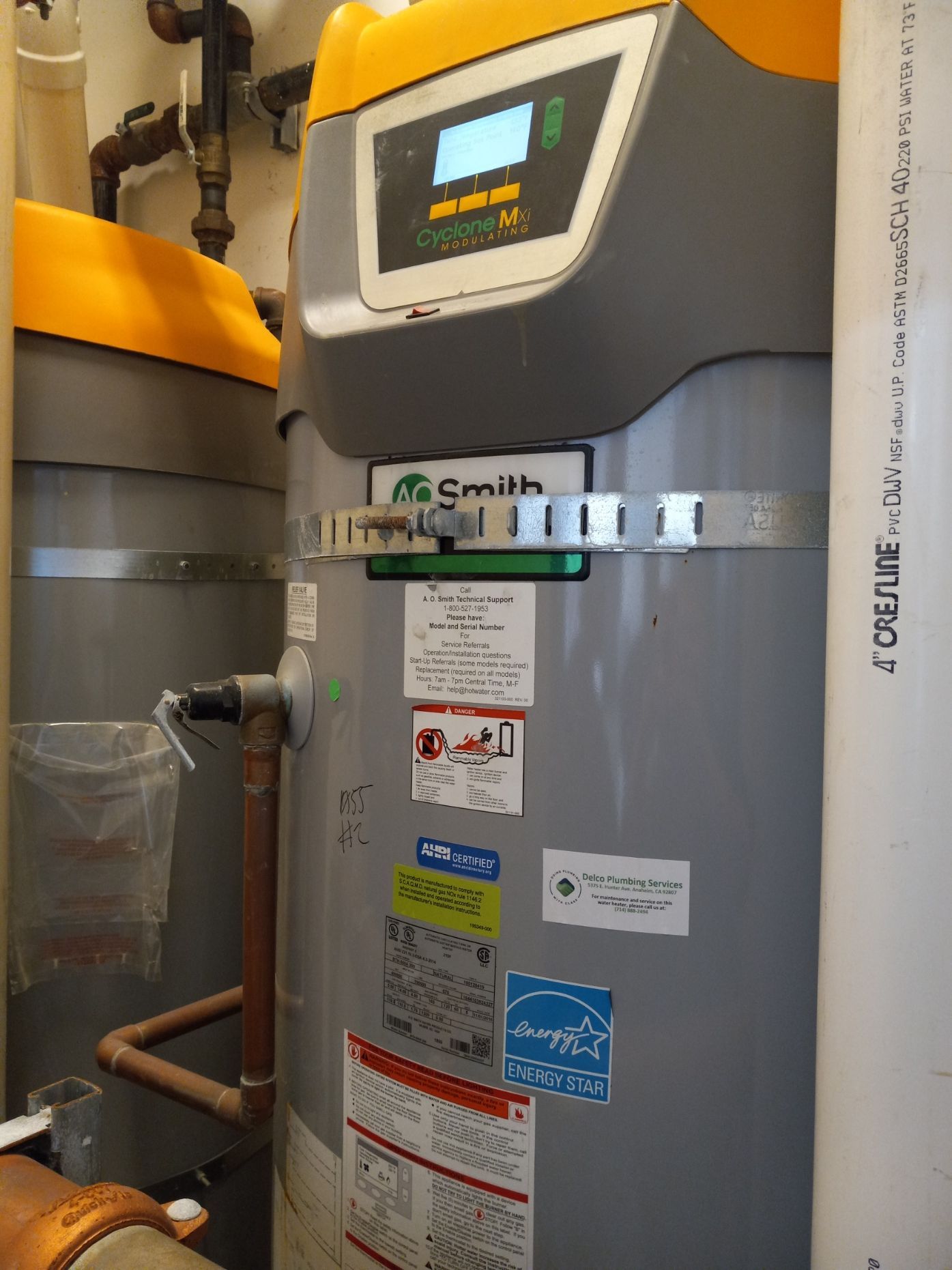 A smith water heater is sitting next to a pipe
