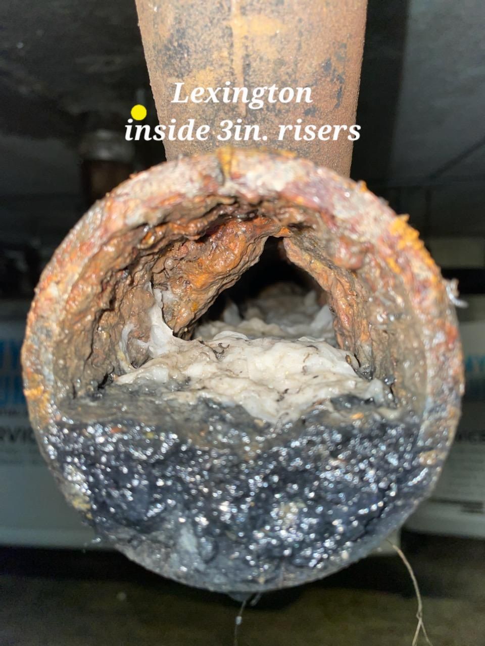 A close up of a rusty pipe that says lexington inside 3in risers