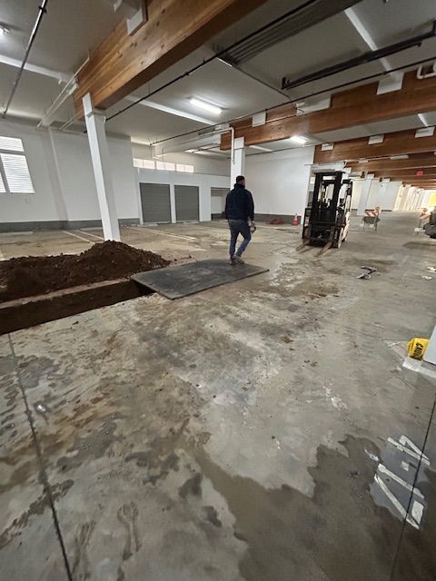 A forklift is moving dirt in a large building