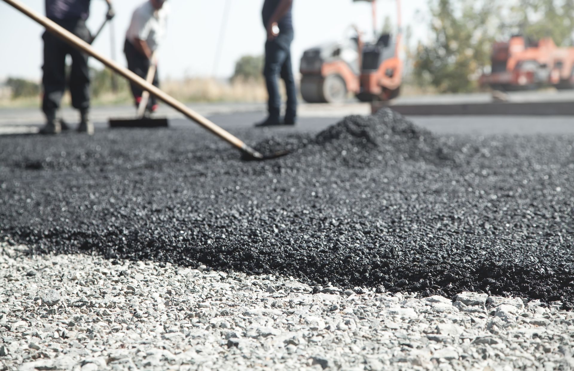Professional crew performing asphalt repairing by spreading hot mix over a prepared gravel base. Professional crew performing asphalt repairing by spreading hot mix over a prepared gravel base.