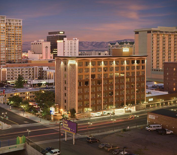 A large building with arches and a car parked in front of it.