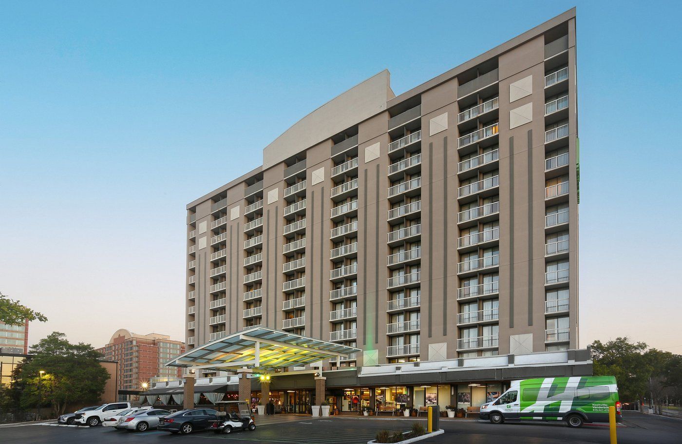 A large building with arches and a car parked in front of it.