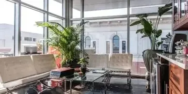 A living room with a lot of windows and furniture.