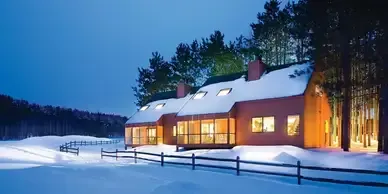 A house in the snow with a fence in front of it