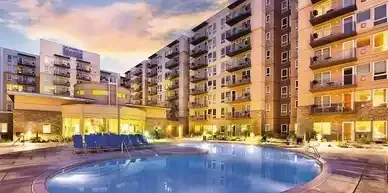 There is a large swimming pool in the middle of a building.