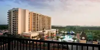 An aerial view of a large building with a pool in front of it.