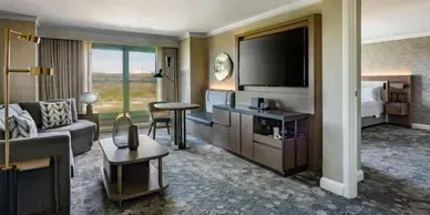 A hotel room with a couch , table , and television.