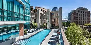 There is a large swimming pool in the middle of a city.