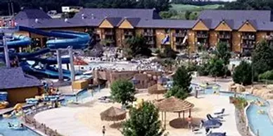 An aerial view of a water park with a large building in the background.