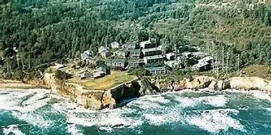An aerial view of a small town on a cliff overlooking the ocean.