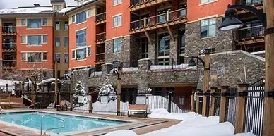 A large building with a swimming pool in front of it.