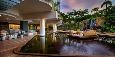 There is a waterfall in the middle of the lobby of a hotel.