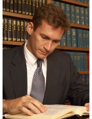 A man in a suit and tie is reading a book