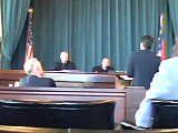 A group of people are sitting in front of a stage in a courtroom.