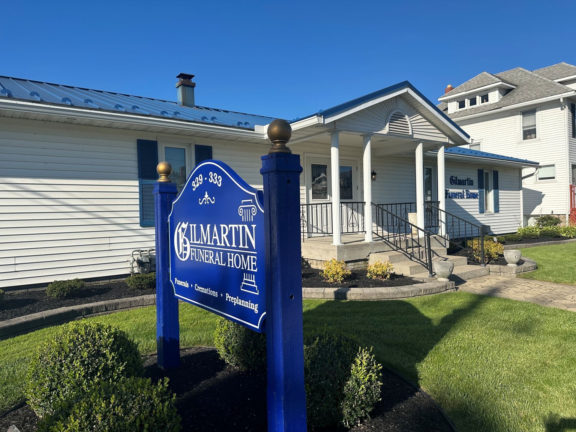 A funeral home with a blue sign in front of it
