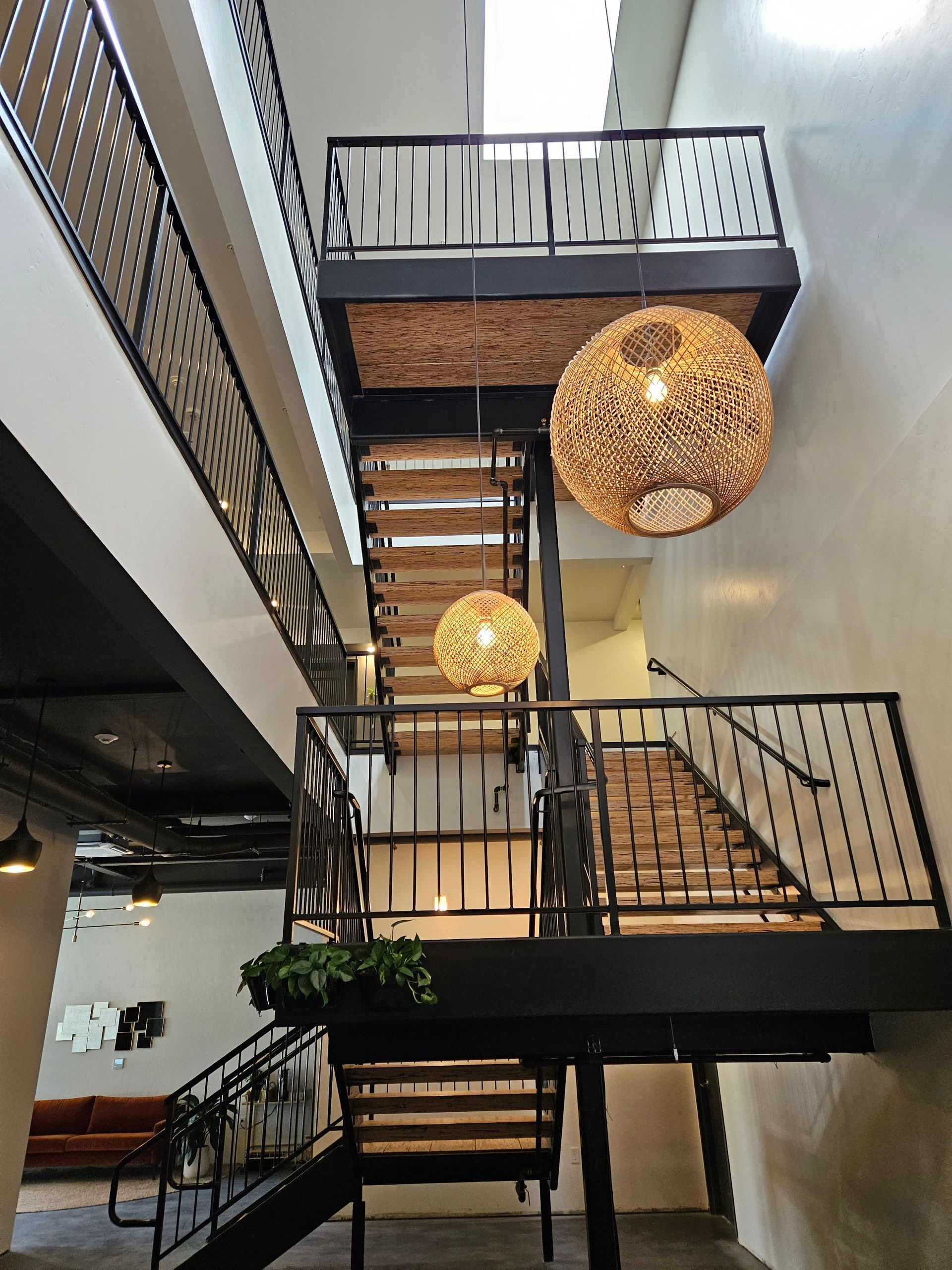 A Building With Stairs And A Balcony With Wicker Lamps Hanging From The Ceiling - Boise, ID - Scott Hedrick Construction