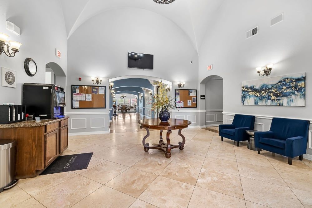 A large lobby with a table and chairs in it at Marquis Rockwall in Rockwall, TX.