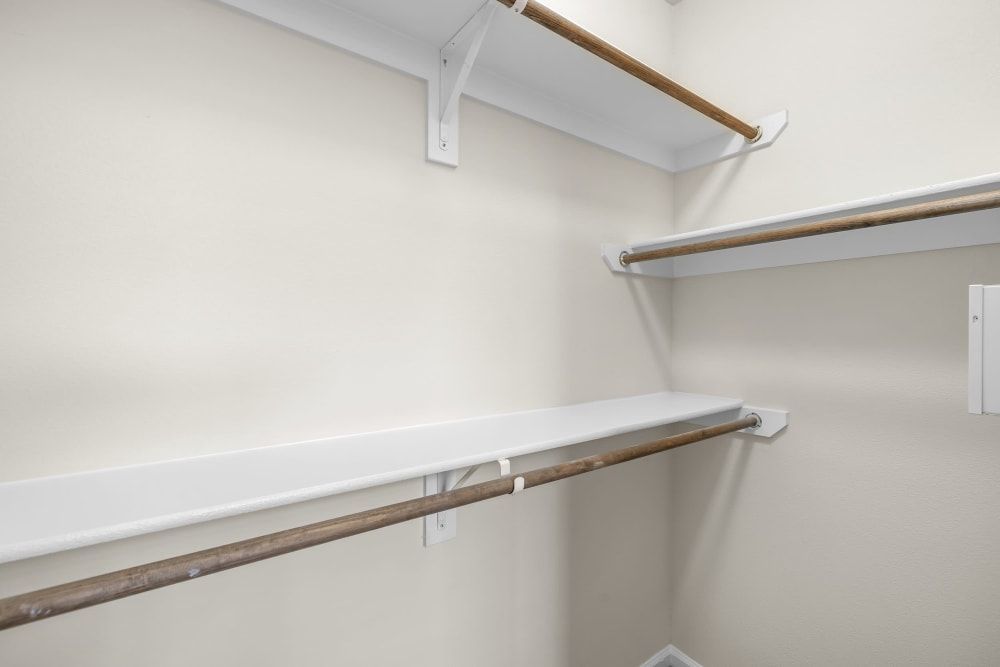An empty walk-in closet with shelves and clothes racks at Marquis Rockwall in Rockwall, TX.