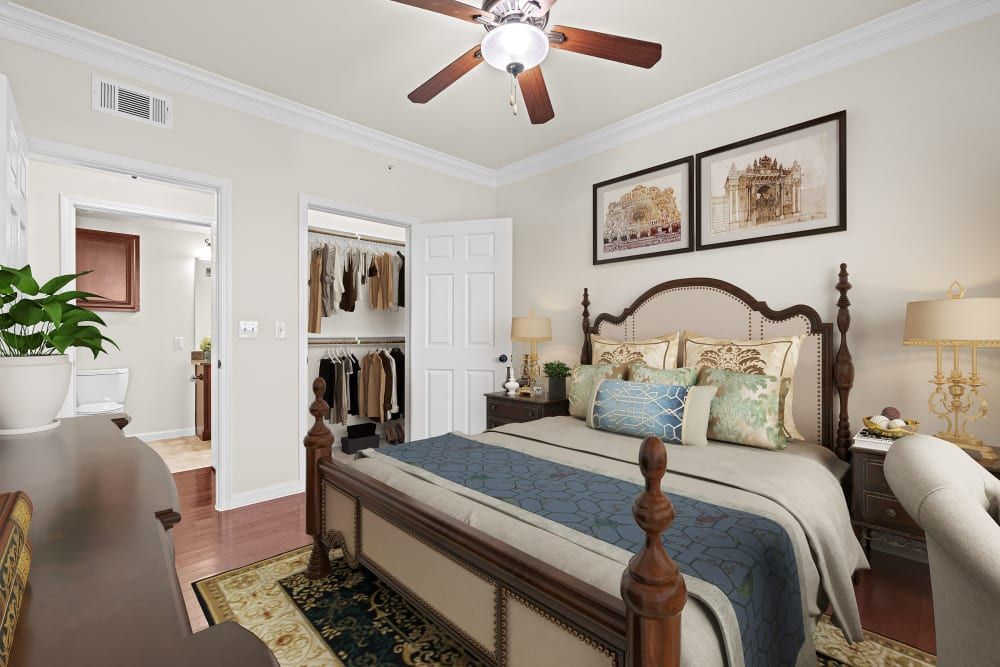 Senior apartment bedroom with a large bed and a ceiling fan at Marquis Rockwall in Rockwall, TX.