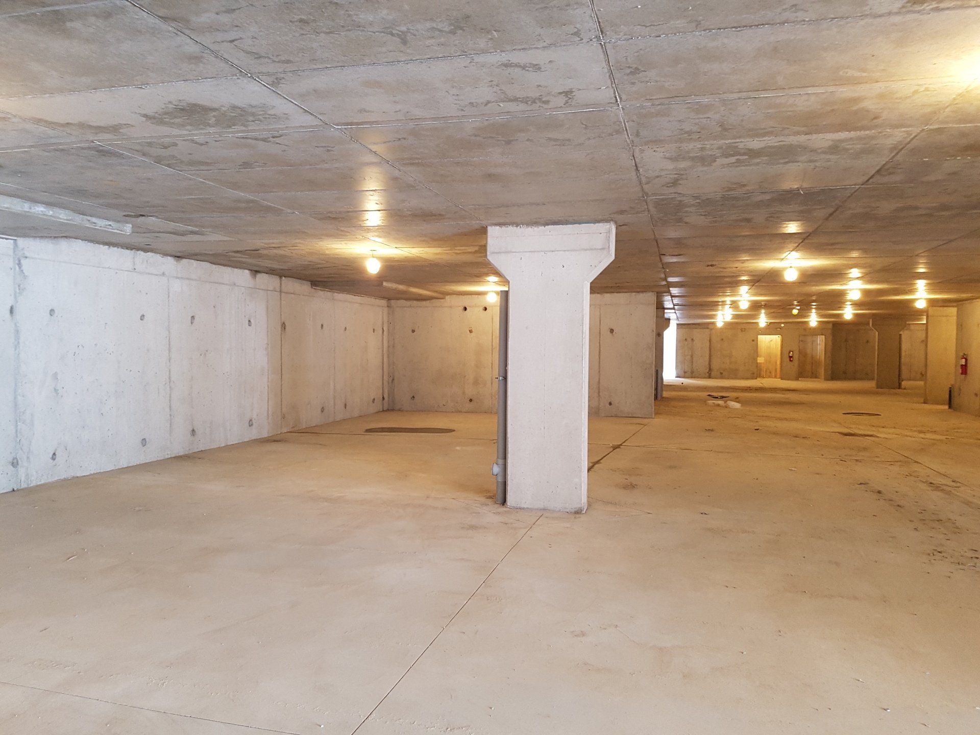 A large empty basement with concrete walls and columns.
