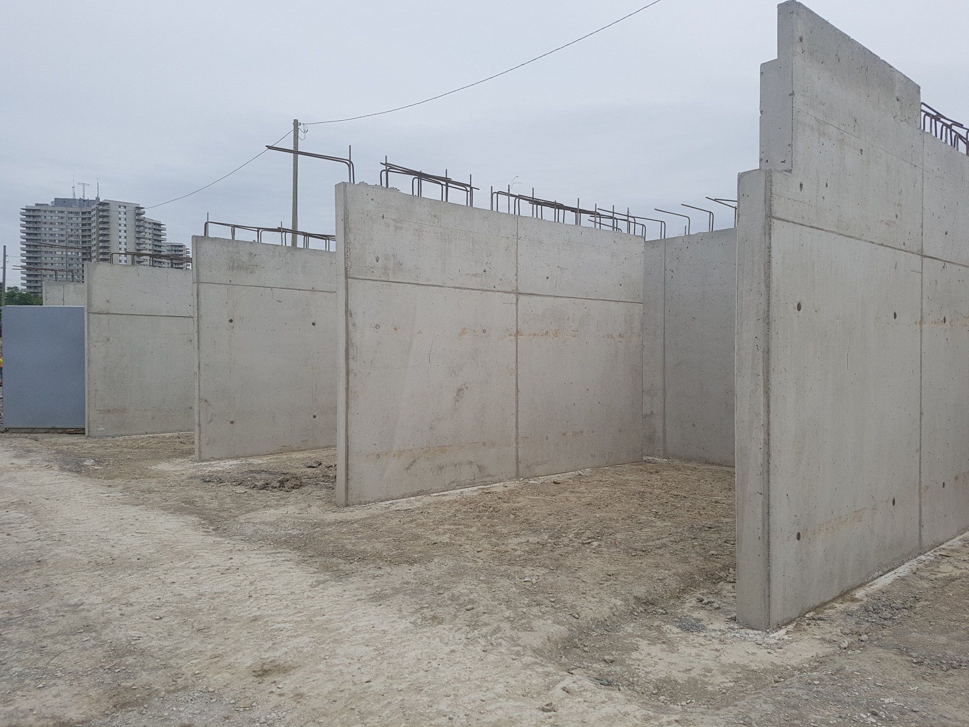 A row of concrete walls in a dirt field
