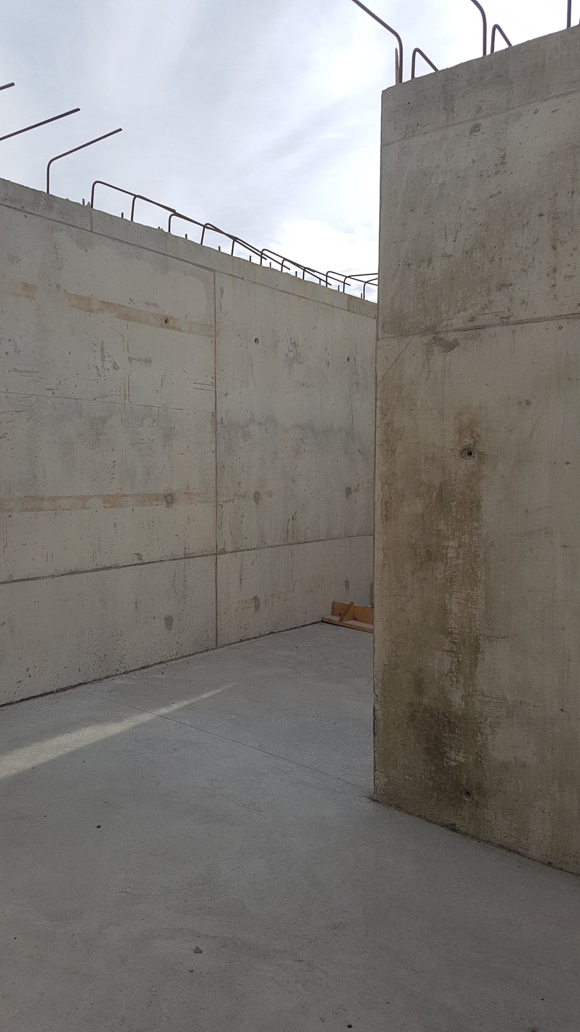 A concrete wall with a metal fence surrounding it