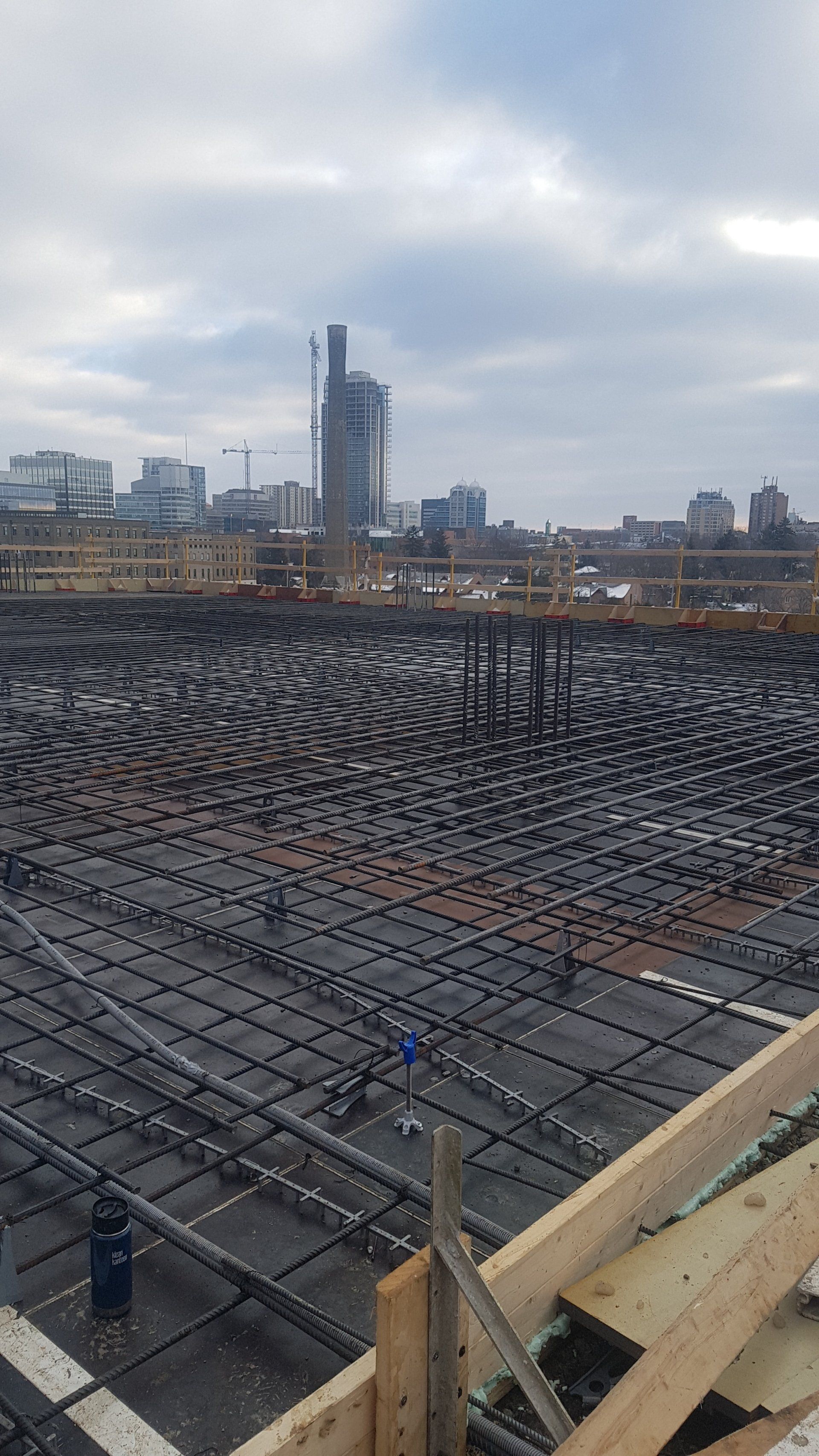 A construction site with a lot of concrete and a city in the background.