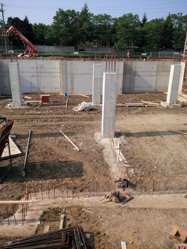 A construction site with a lot of dirt and concrete pillars.