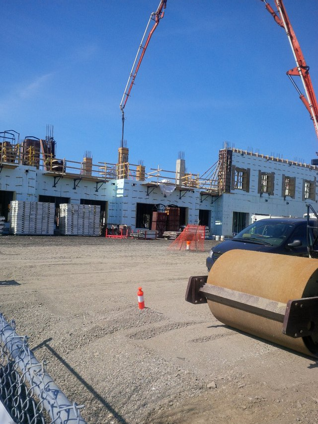 A truck is parked in front of a building under construction