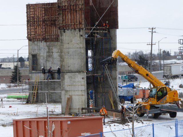 A construction site with a yellow crane in the foreground