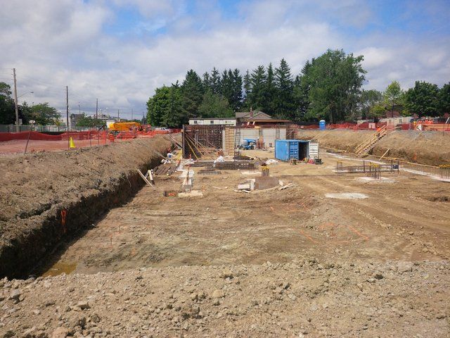 A construction site with a lot of dirt and trees in the background