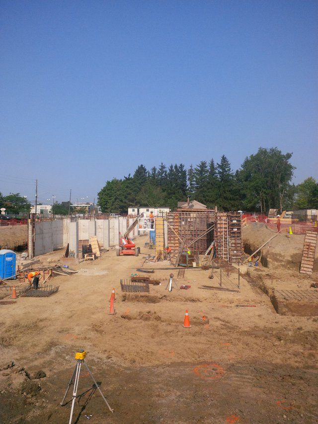 A construction site with a lot of dirt and trees in the background.