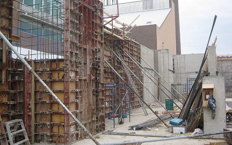 A construction site with scaffolding and a building in the background