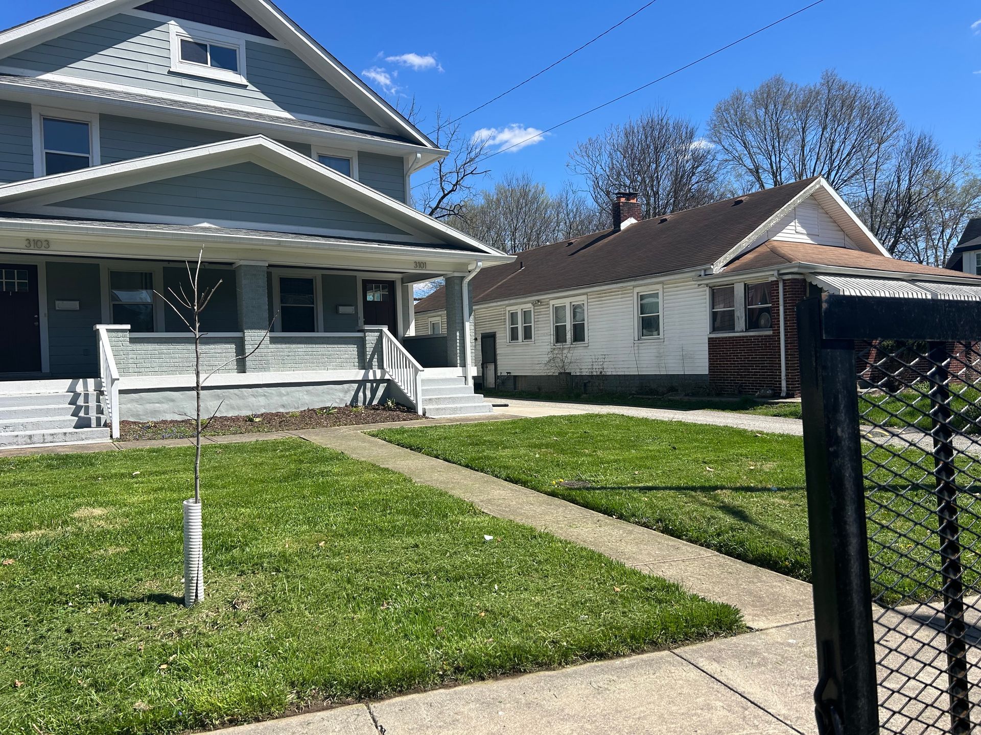 A couple of houses are sitting next to each other on a sunny day.