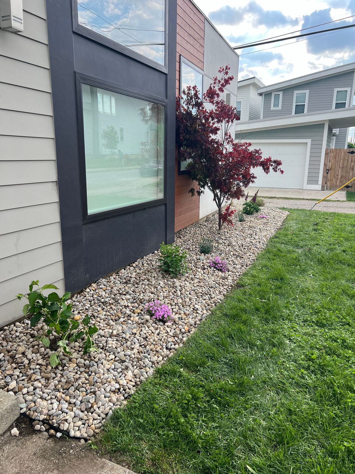 A house with a lot of black mulch on the side of it.