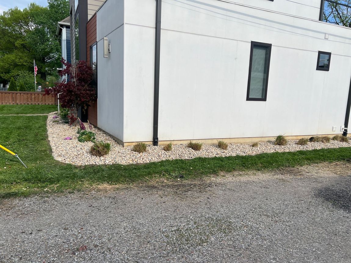 A white house with a lot of gravel in front of it.