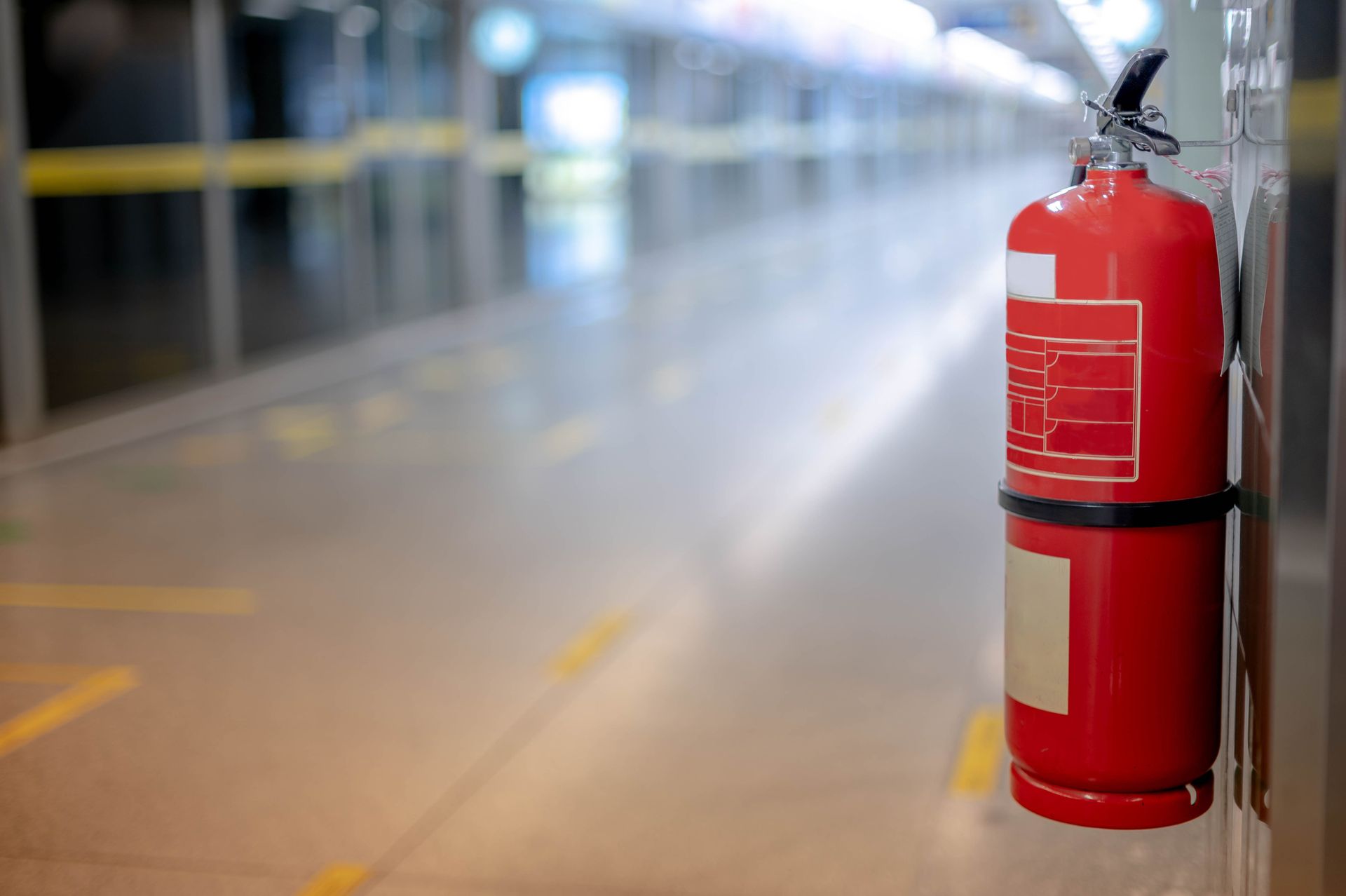 A red fire extinguisher is mounted on a wall, ready for use in case of fire emergencies.