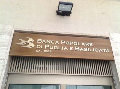 Sign for Banca Popolare di Puglia e Basilicata over a bank entrance; brown and gold logo.