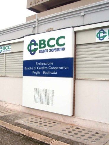 Insegna della banca BCC Credito Cooperativo in Italia. Sfondo bianco, logo verde e blu, esterno.