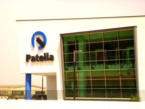 Edificio con il logo Patella, facciata blu e bianca, finestre colorate di verde.