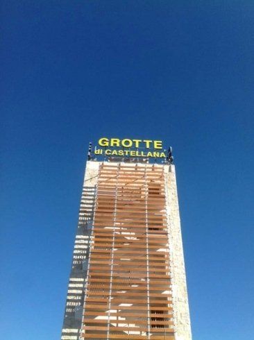 Un edificio alto e rettangolare con un cartello che recita